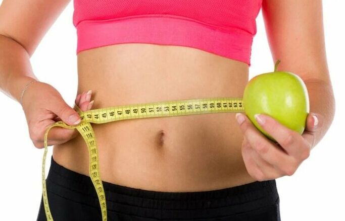 The girl measures the waist volume